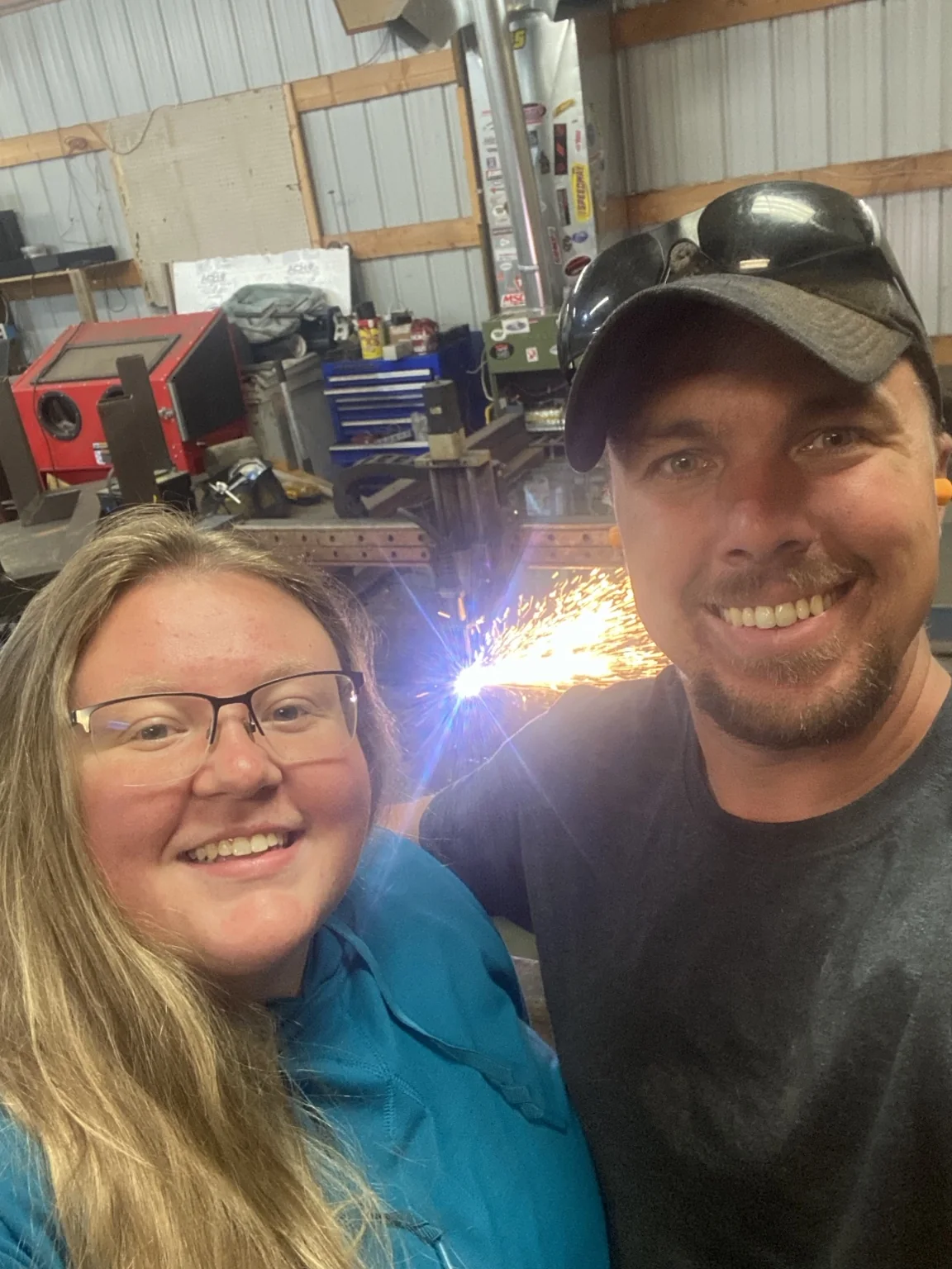 Adam and Megan in front of the CNC plasma table during its first cut in a shop they owned