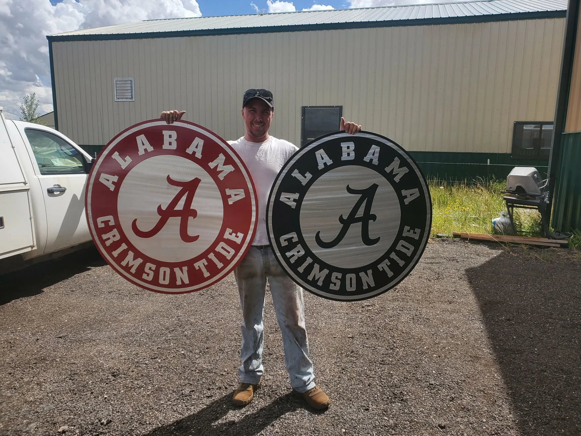 Adam holding solid-aluminum University of Alabama signs in Crimson Red and Hammer Black powder coat