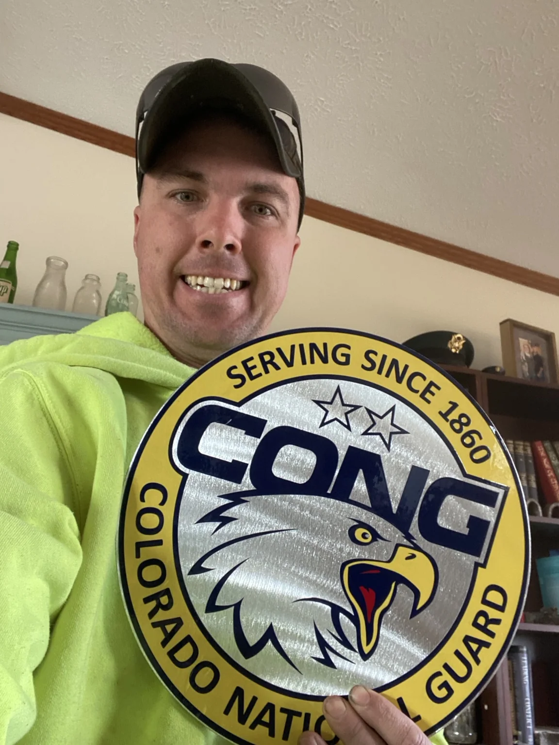 Adam holding one of twelve brushed-aluminum Colorado National Guard symposium plaques
