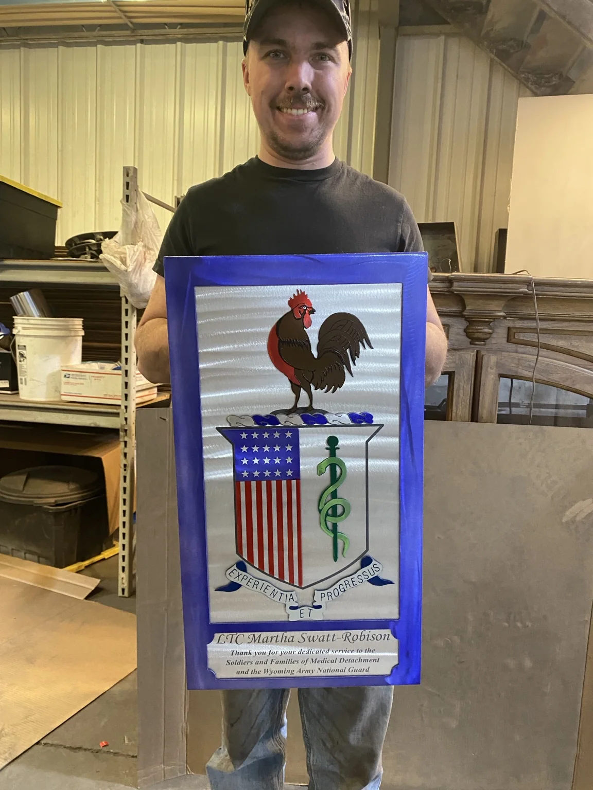Adam holding an all-aluminum farewell gift made for an Army National Guard medical provider