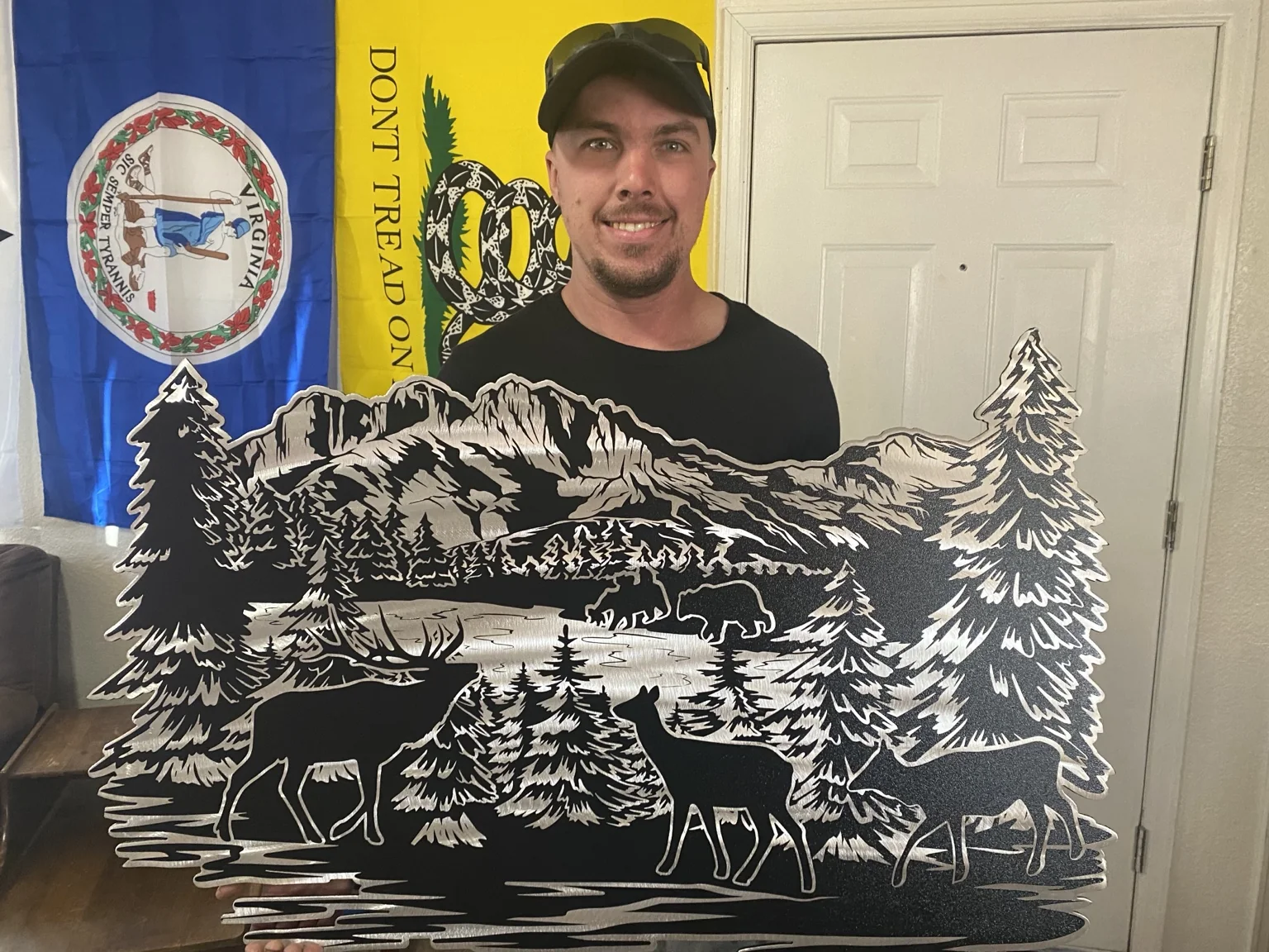 Adam holding a free memorial wildlife metal artwork created with a grieving family