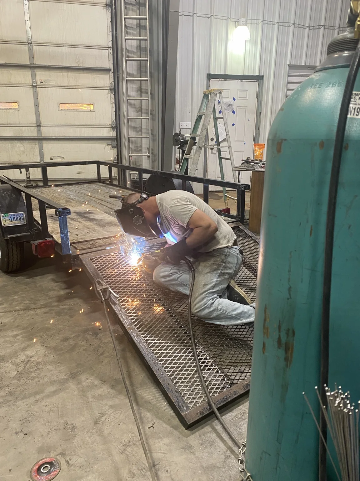 Adam welding expanded metal on a trailer for additional strength